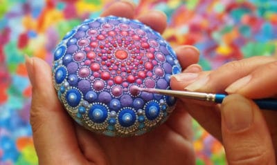 artist painting rocks with paint pens