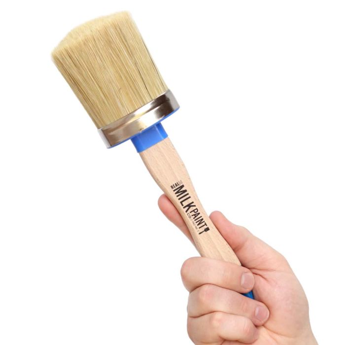 Hand holding up a wax brush
