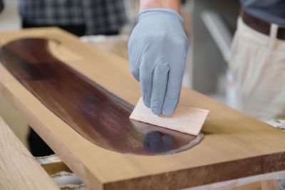 man working on a DIY noodle board stained with a darker color than the original hardwood