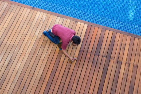 man applying outdoor defense oil on deck instead of other oil-based stains