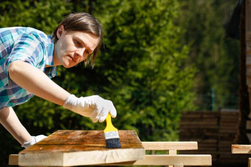 man applying hemp oil on his woodworking project