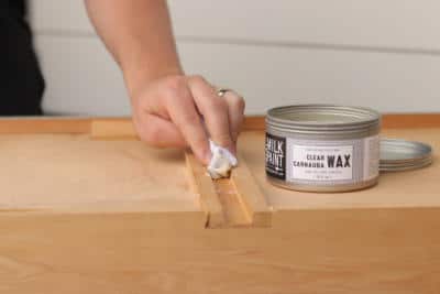 man trying to fix sticky wooden drawers with carnauba wax