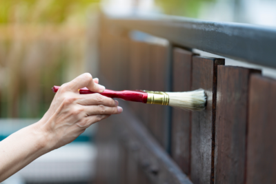 a person protecting wood furniture using the best protection for exterior wood furniture and surfaces