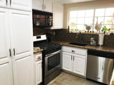 white milk paint kitchen cabinets and modern kitchen appliances