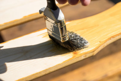 A brush applying a finish on wood, demonstrating tung oil vs linseed oil effects