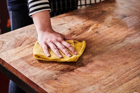 cleaning the wood furniture with a damp cloth